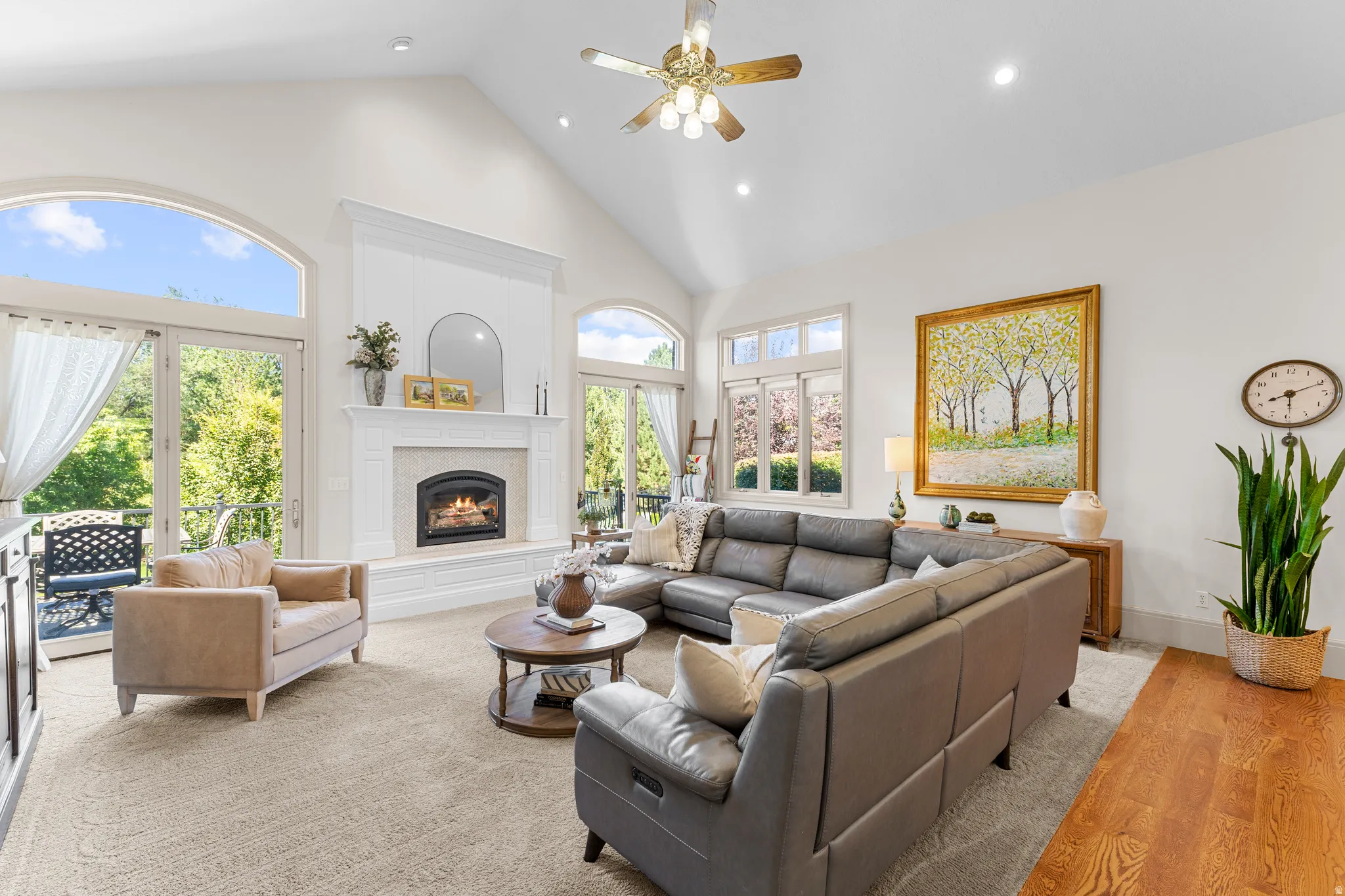 Vaulted ceilings, a built-in fireplace, and expansive arched windows defining the space