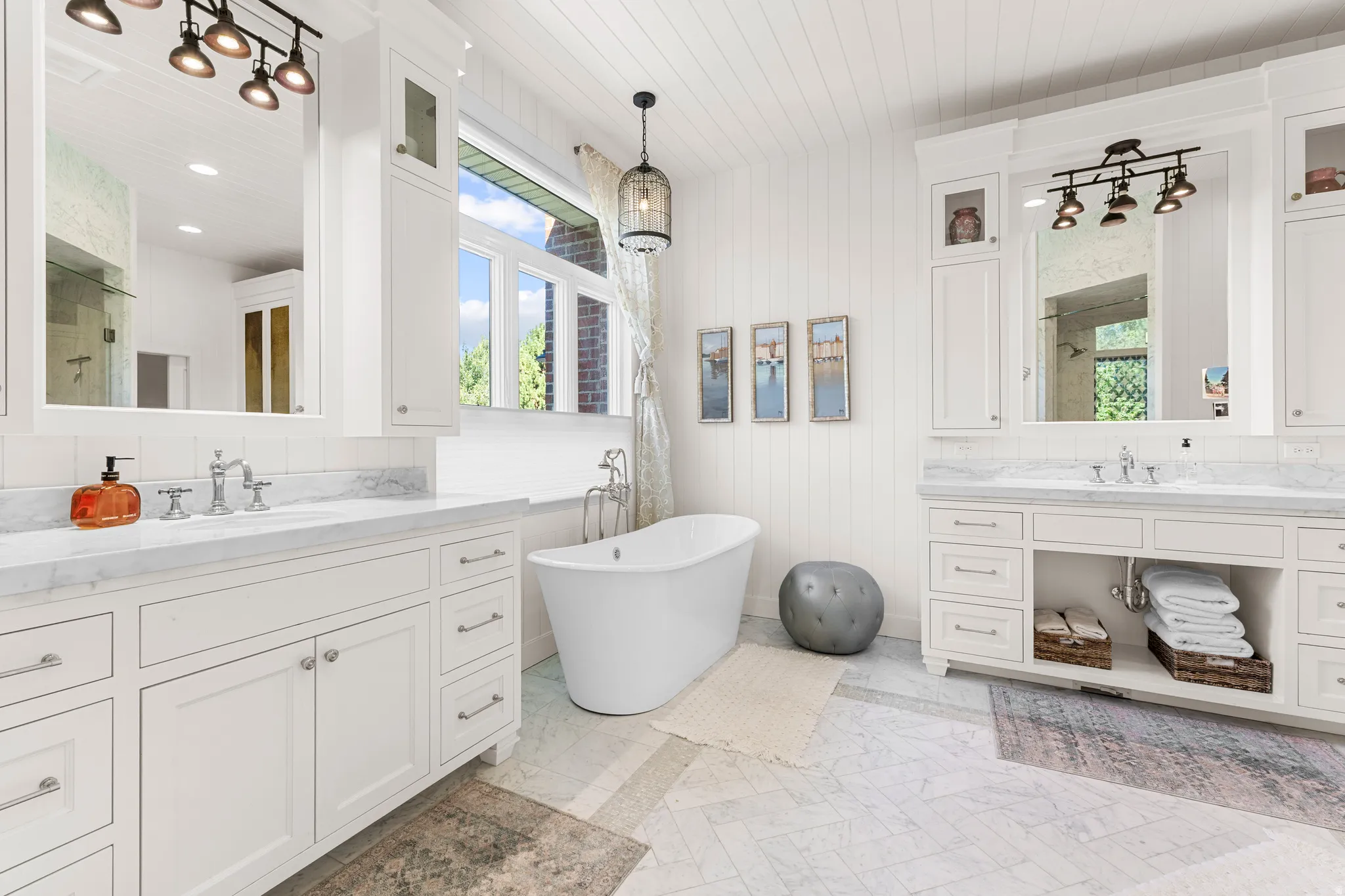 Dual vanity with white cabinetry and stone countertops, freestanding soaking tub, shiplap wall paneling.