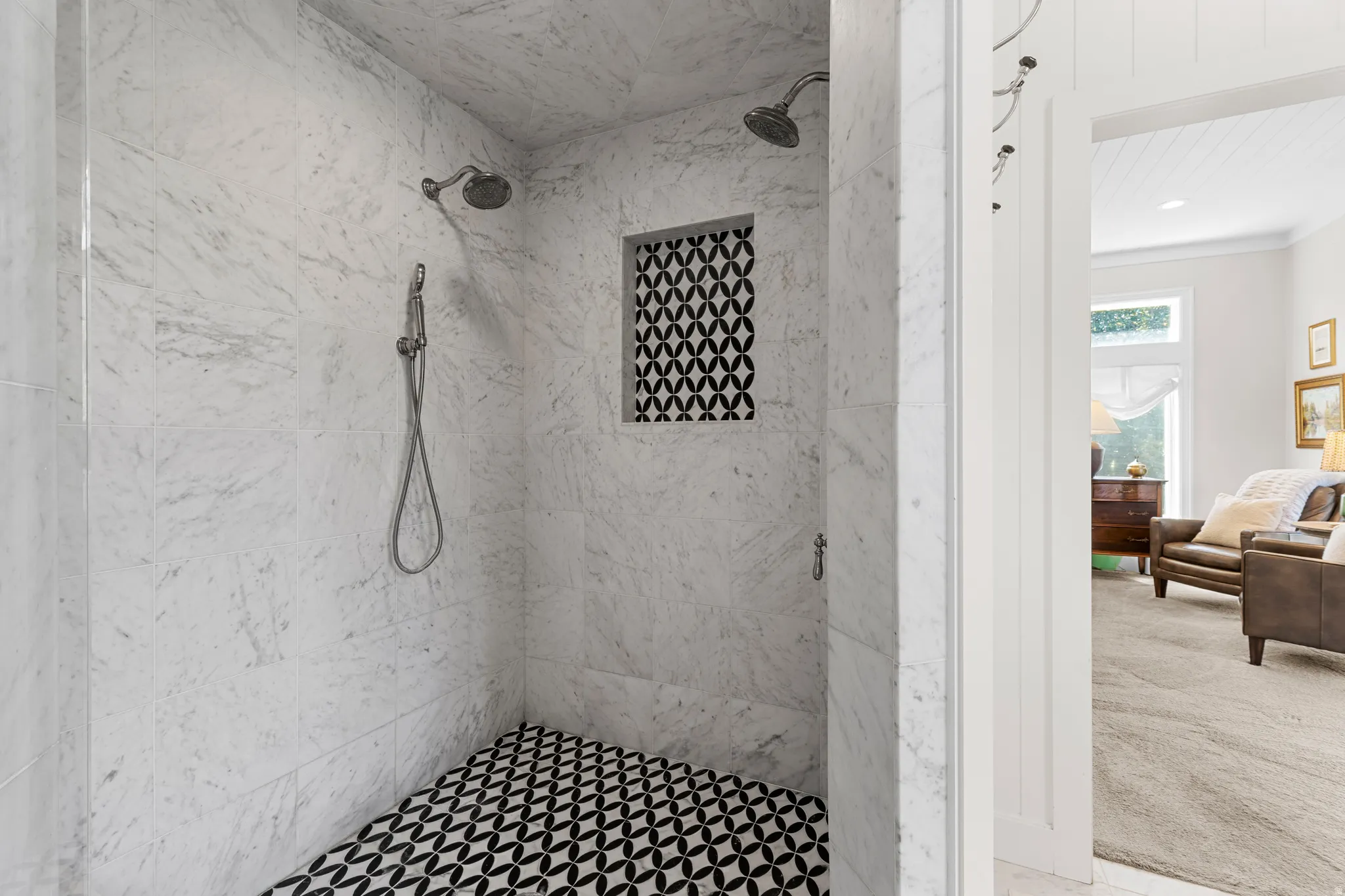 Walk-in shower with marble-finish wall tiling, dual shower heads, and patterned floor tiling