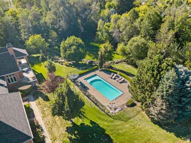 Rectangular outdoor pool with stone surround and black metal fencing