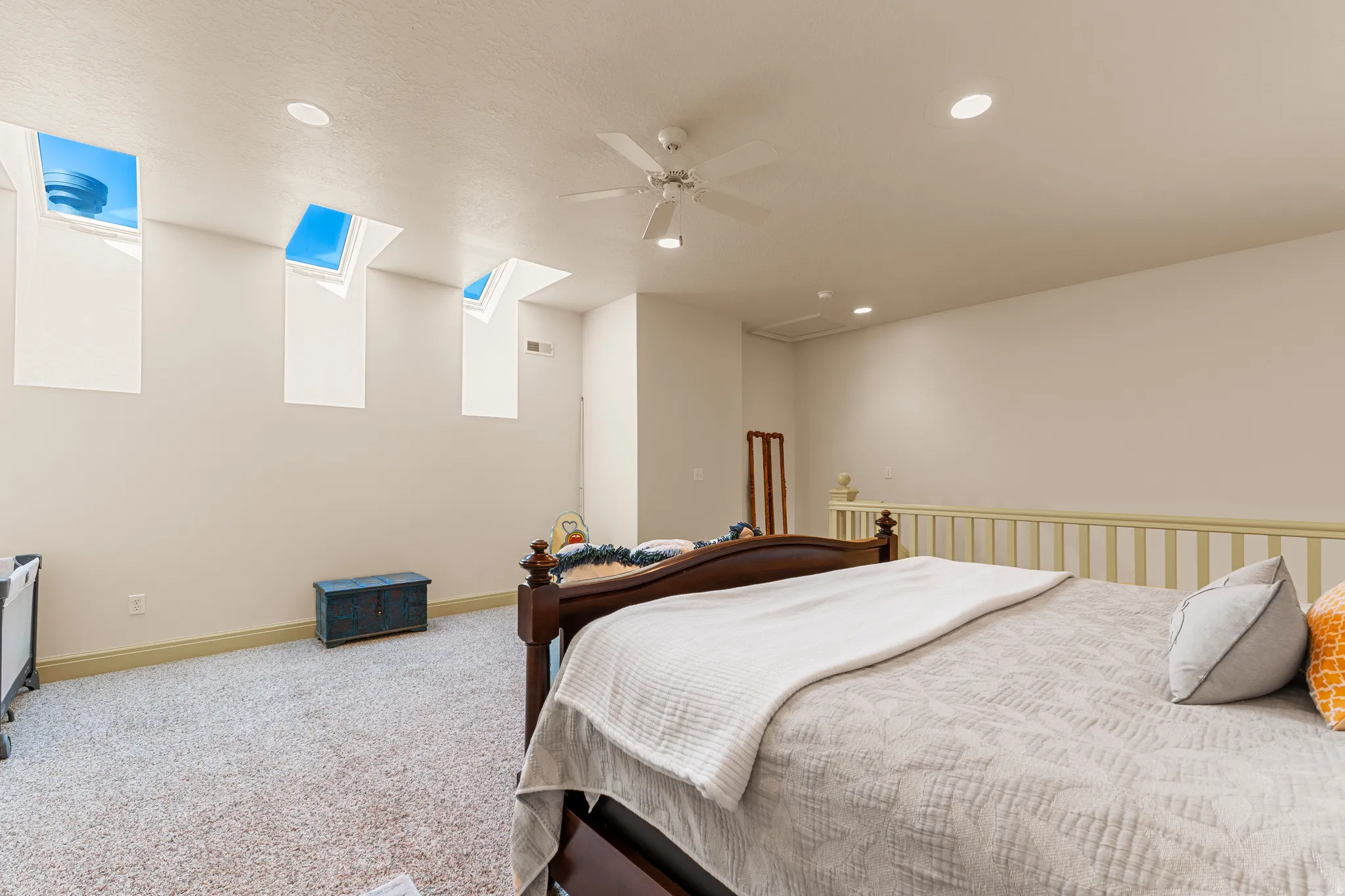 Recessed lighting, three skylights, ceiling fan, and carpeted flooring