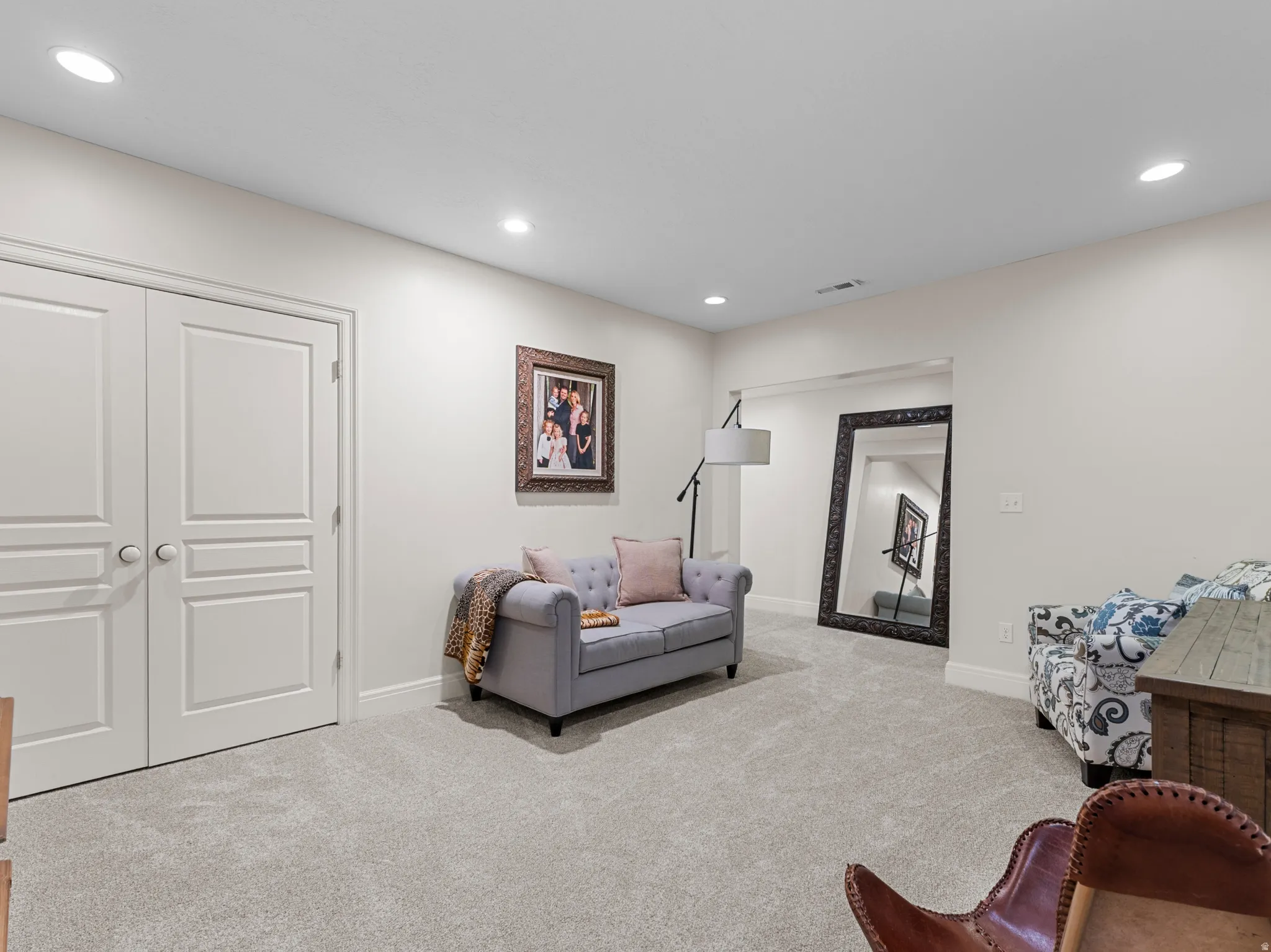 Recessed ceiling lighting, light-toned wall paint, neutral-toned carpeting, white interior doors, and a decorative wall niche