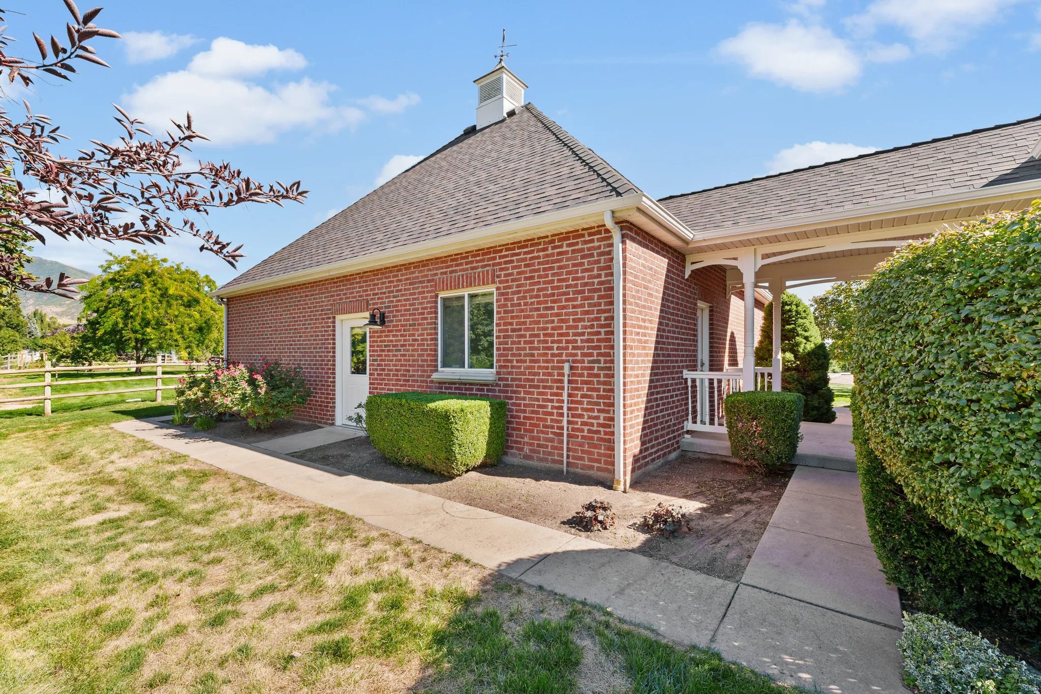 Brick exterior with a dark shingle roof and white gutters