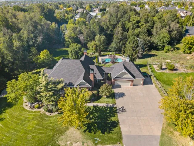 Expansive property featuring a multi-car driveway, attached garage, and mature landscaping