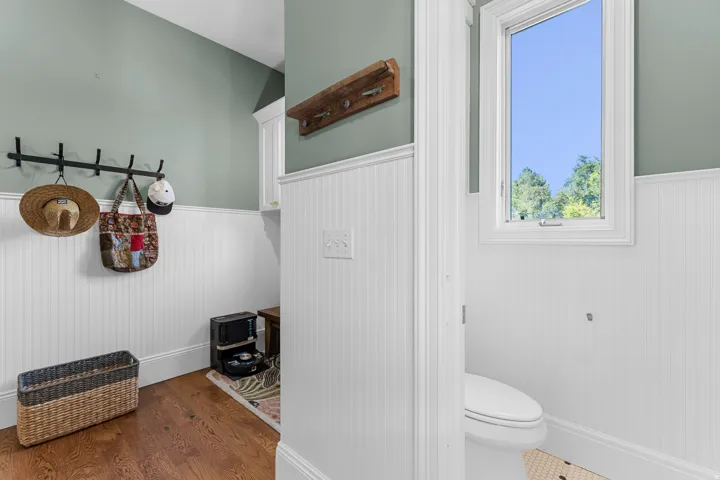 Hardwood-style flooring, wainscoting, built-in cabinetry, and a window with natural light
