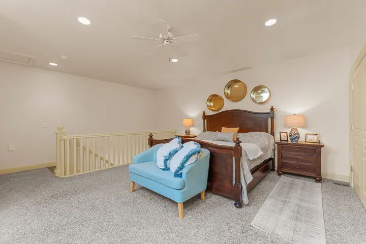 Carpeted bedroom space featuring recessed lighting, a ceiling fan, a wooden bed frame, and wooden nightstands