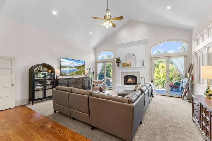 Vaulted ceiling, recessed lighting, fireplace with mantel, French doors, and hardwood flooring