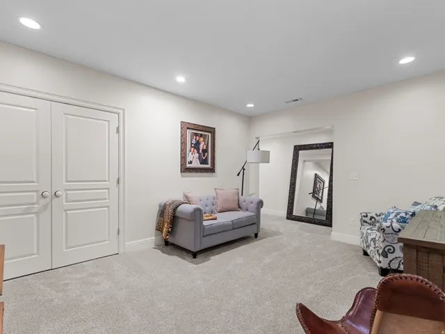 Recessed ceiling lighting, light-toned wall paint, neutral-toned carpeting, white interior doors, and a decorative wall niche