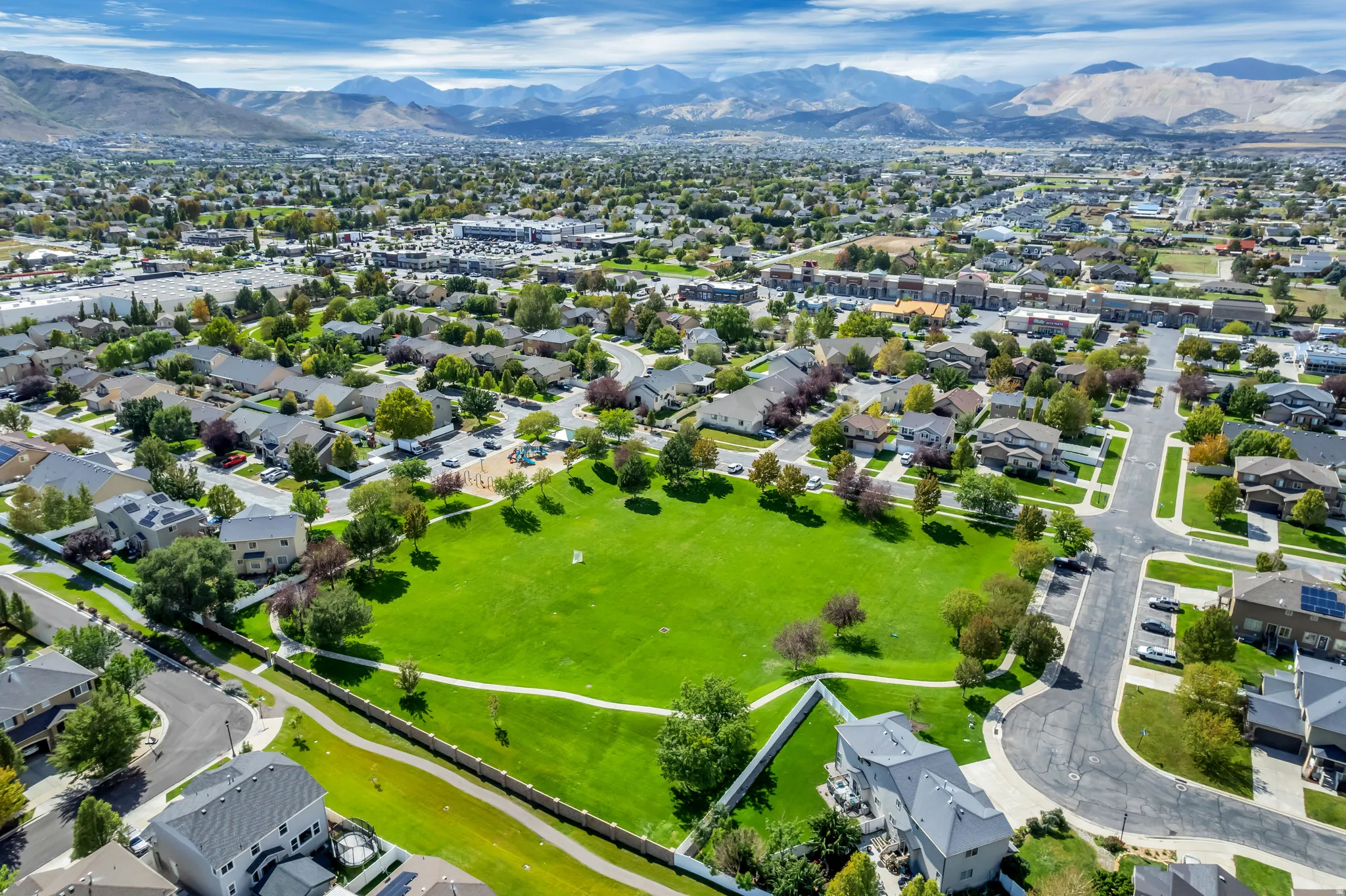 Expansive community with a central green space, surrounded by residential properties and mature trees