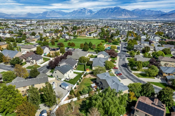 Expansive residential area featuring a central green space, paved streets, and a mountainous backdrop