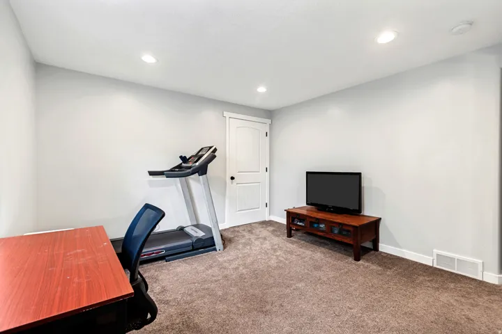 Recessed lighting, light-toned wall paint, and textured carpeting
