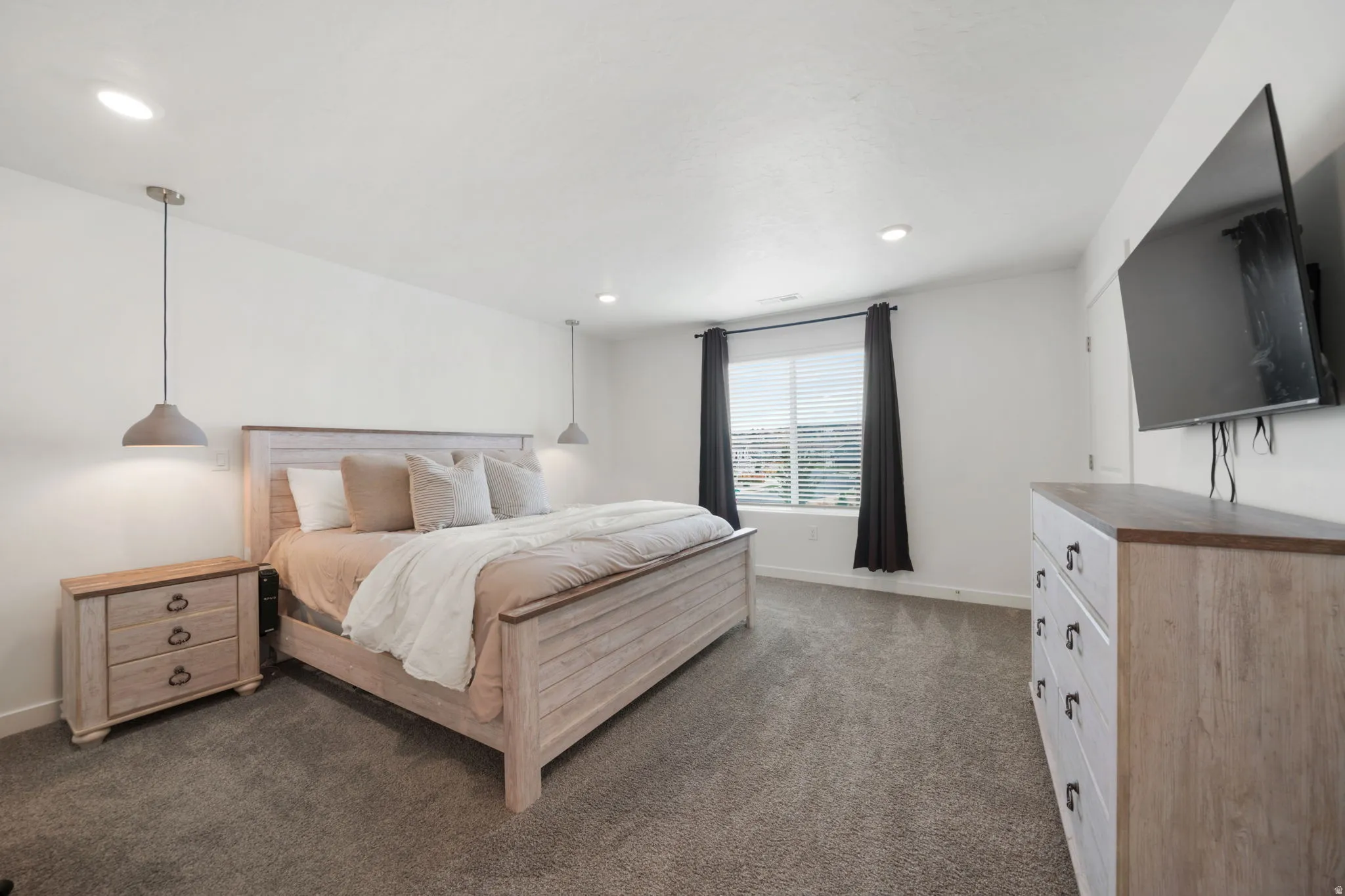 Recessed ceiling lighting, two pendant light fixtures, window with blinds, and carpeted flooring