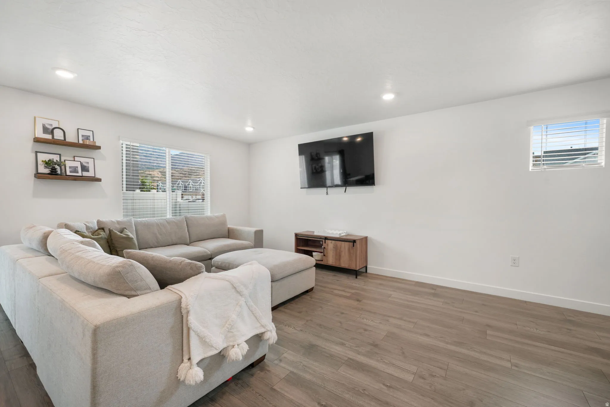 Recessed lighting, wood-finish flooring, and white walls create a bright interior