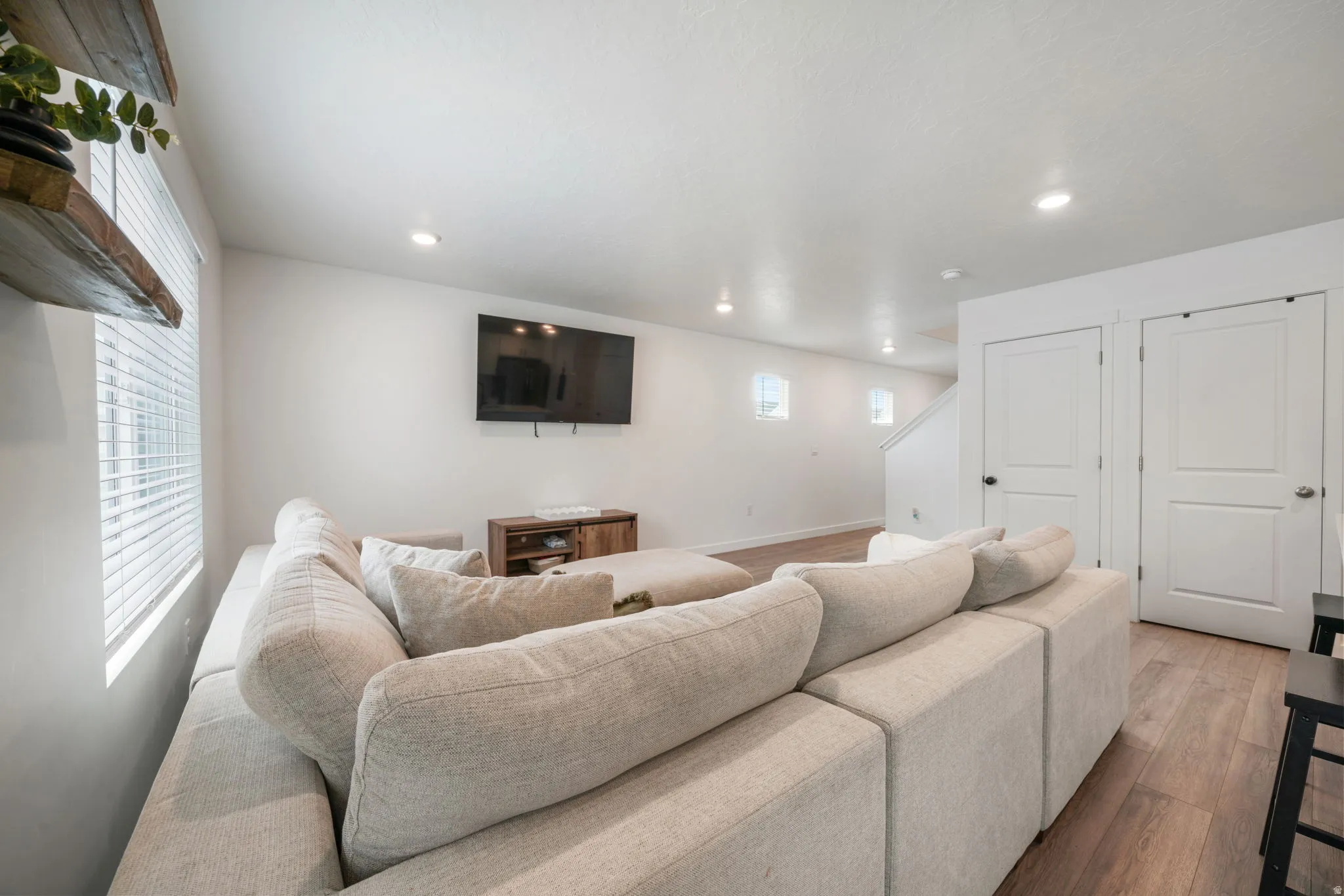 Recessed lighting, wood-finish flooring, and white walls
