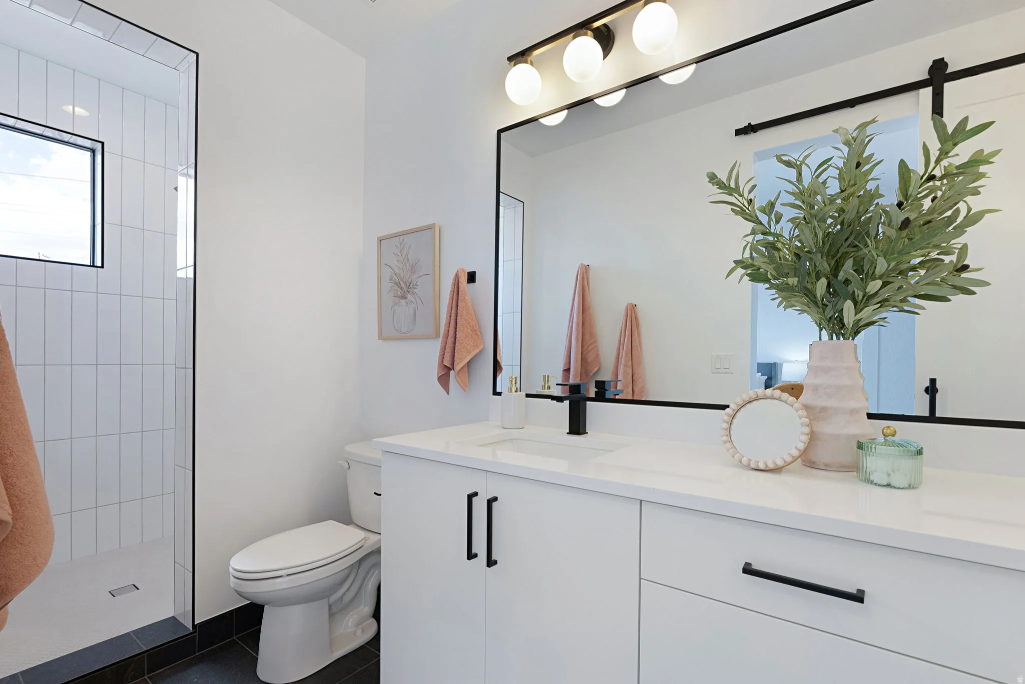 White vanity with single sink, quartz countertop, and matte black faucet