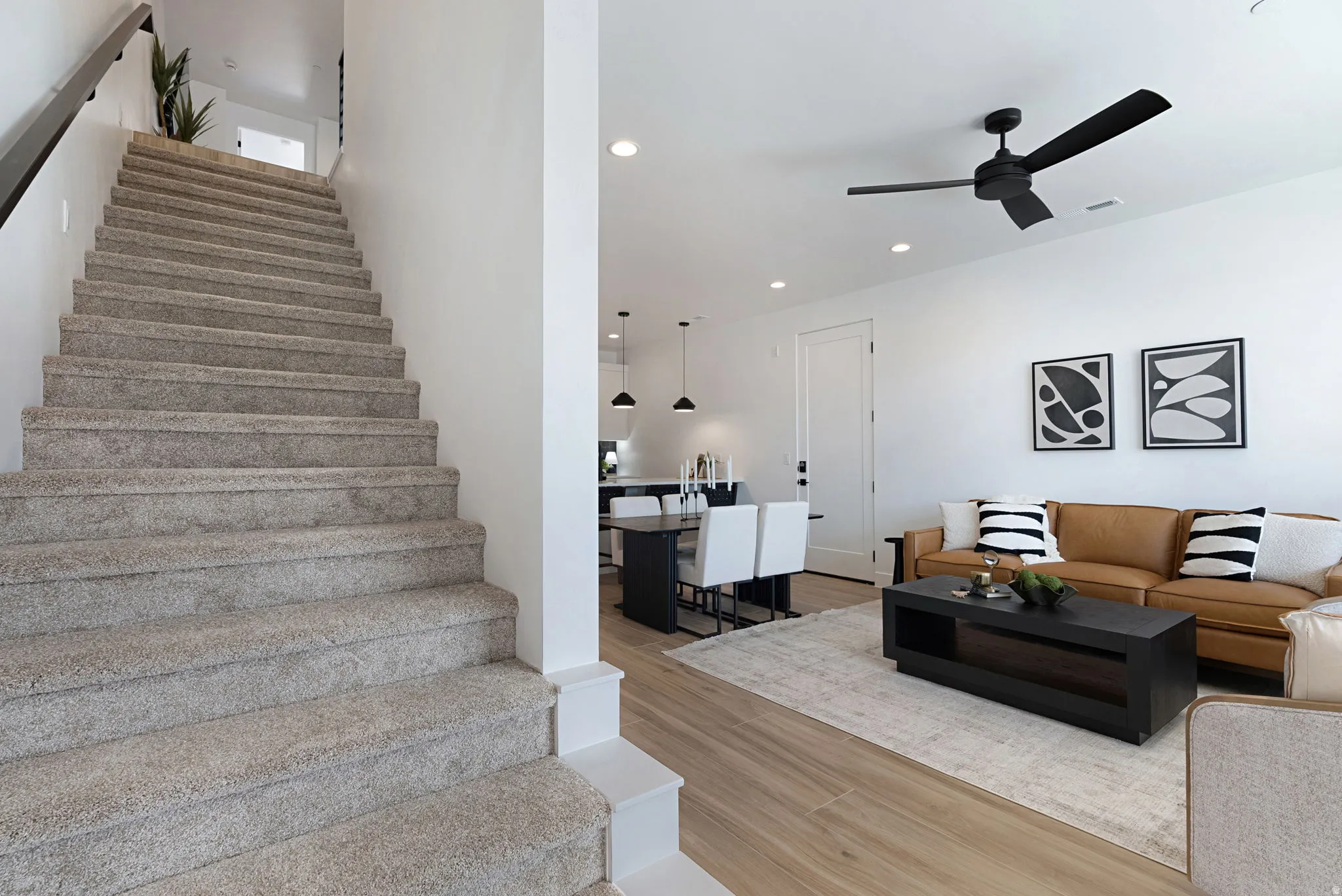 Open-concept living area with wood-finish flooring, recessed lighting, and a modern ceiling fan