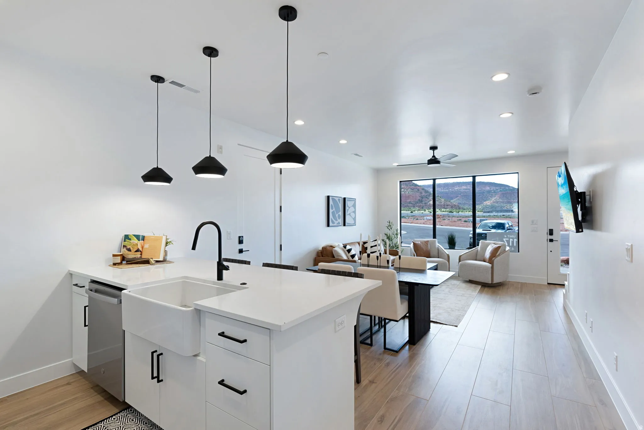Modern kitchen island with a farmhouse sink, stainless steel dishwasher, and pendant lighting