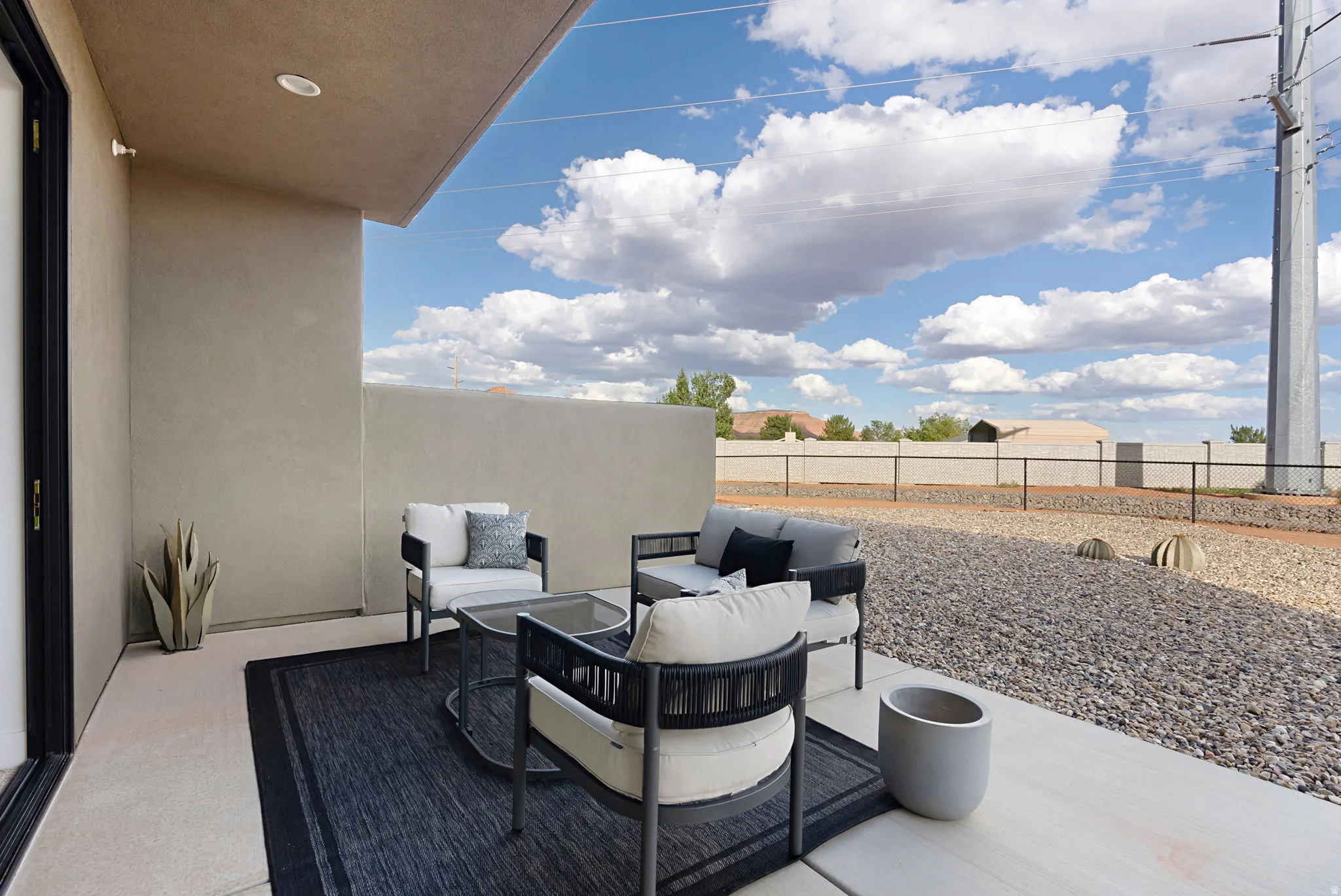 Private patio with recessed lighting, concrete flooring, and gravel landscaping