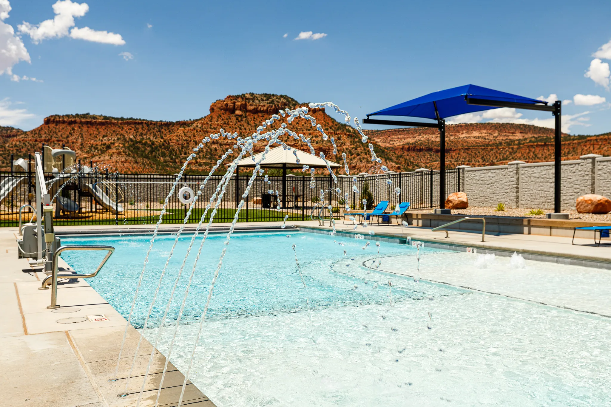 Swimming pool with integrated fountains, sun shelf, and accessibility lift