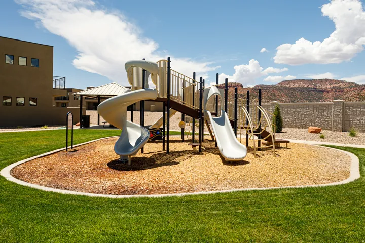 Recreational playground featuring two slides, a climbing structure, and wood chip surfacing