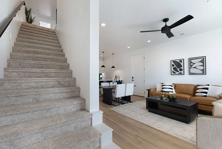 Open-concept living area with wood-finish flooring, recessed lighting, and a modern ceiling fan