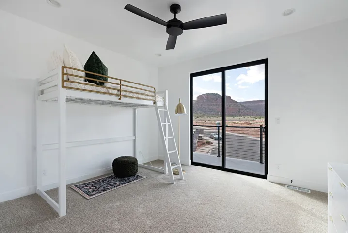 Recessed lighting, ceiling fan, sliding glass door, mountain scenery, and light-toned carpeting