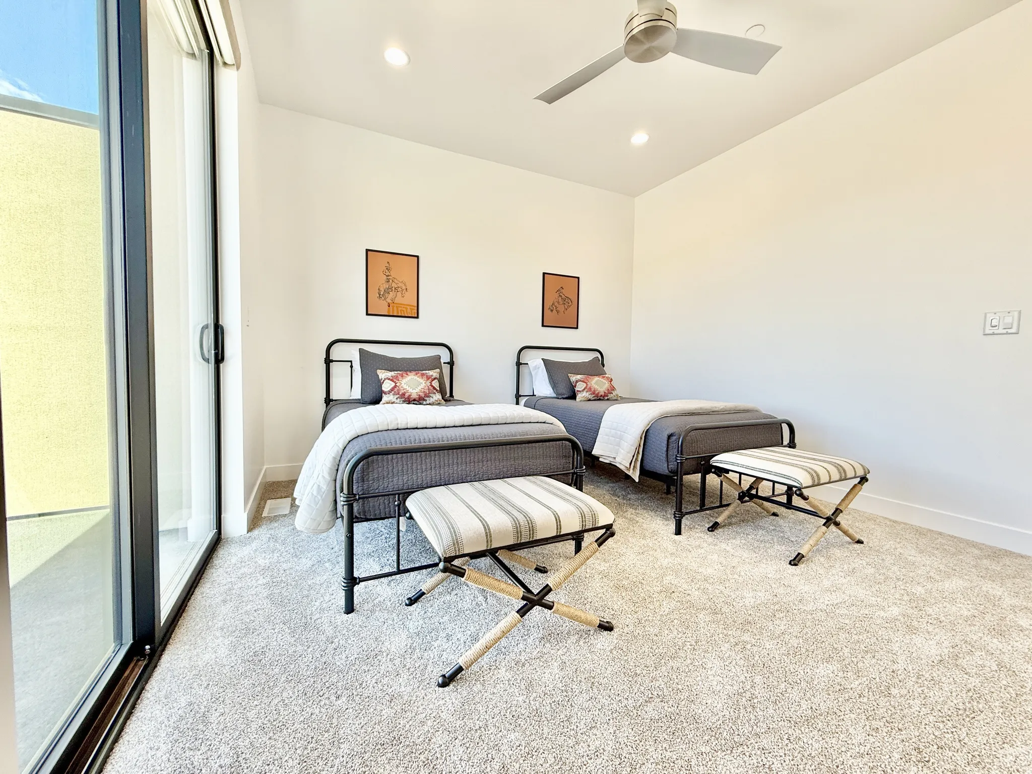 Vaulted ceiling with recessed lighting and ceiling fan, light-colored carpet flooring, and a sliding glass door