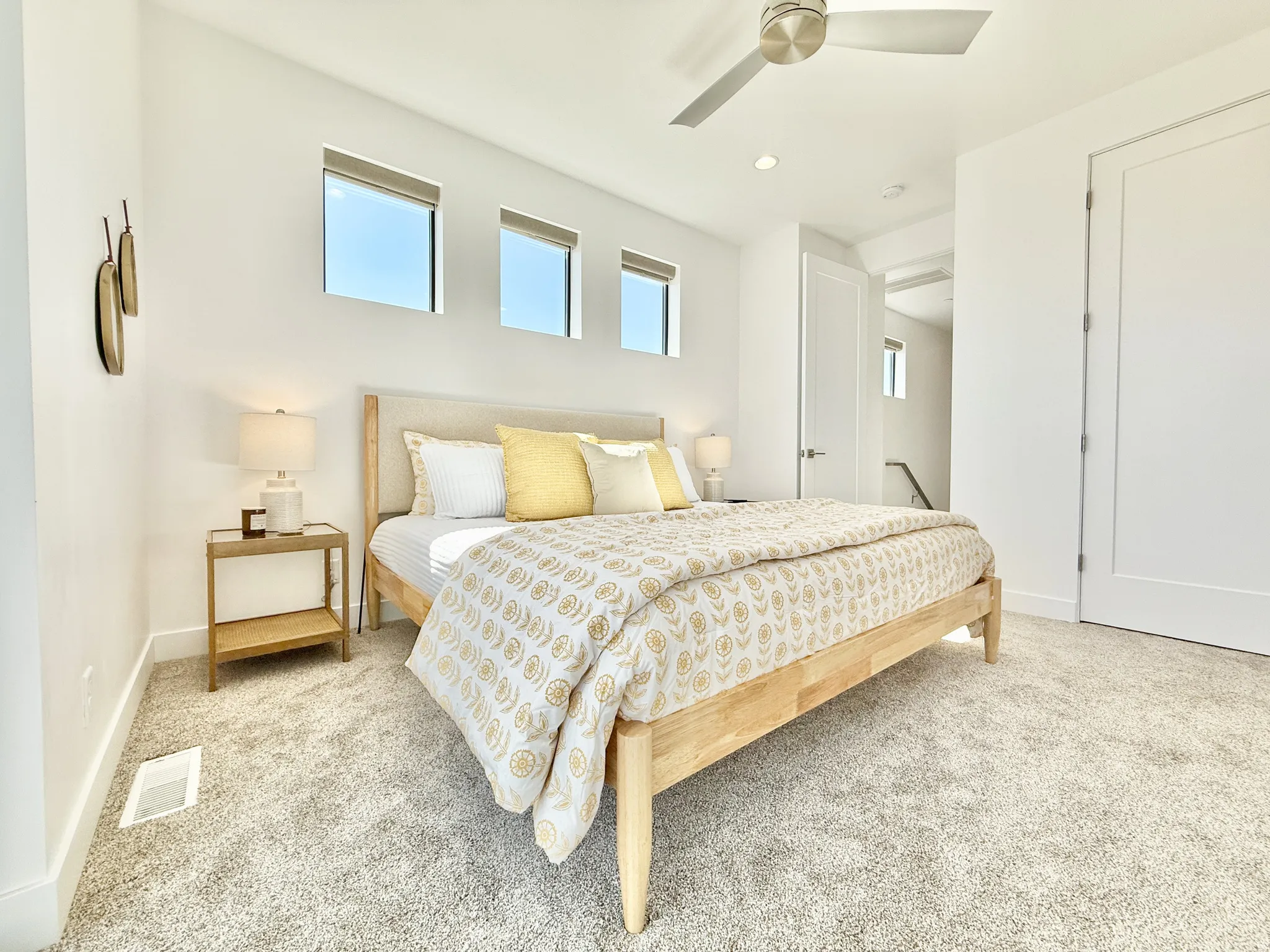 Recessed lighting, ceiling fan, three horizontal windows, and light-colored carpeting