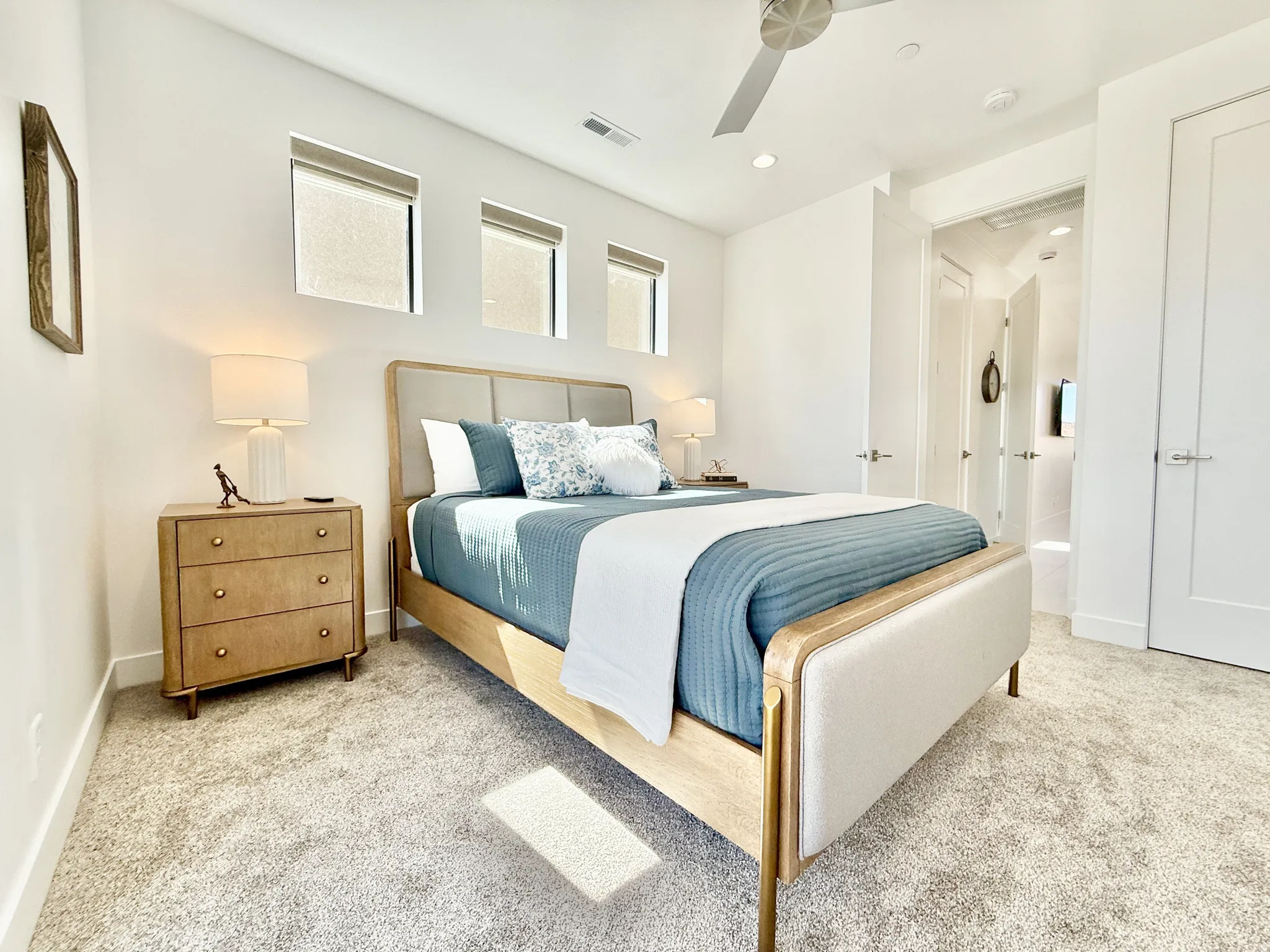 Recessed lighting, ceiling fan, three transom windows, white paneled doors, and light-toned carpet