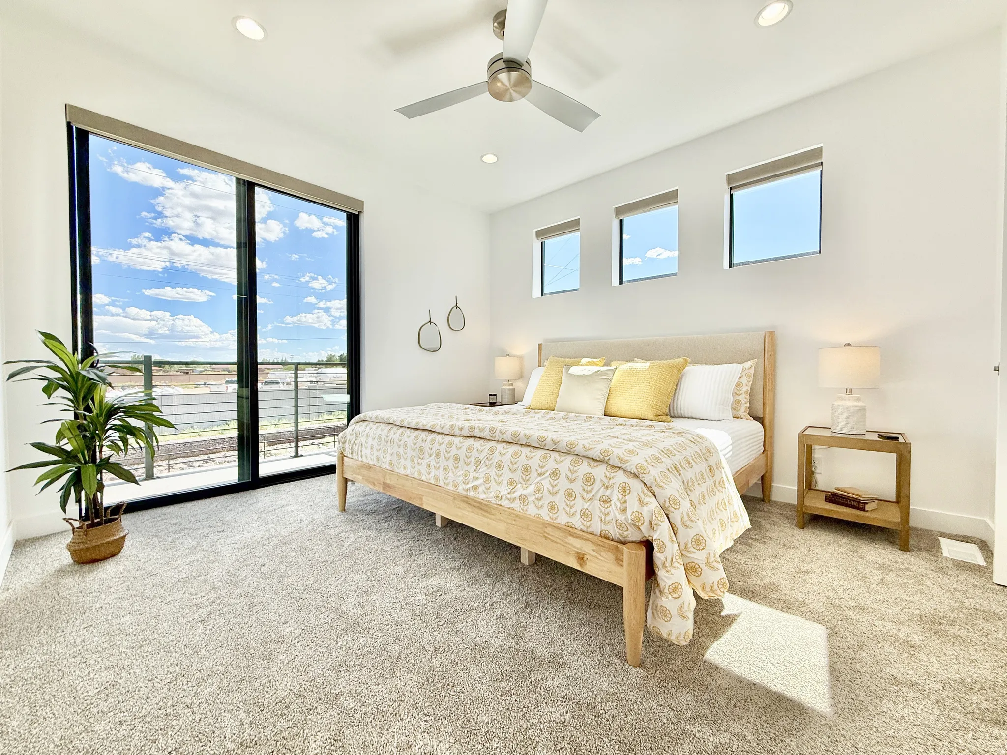 Expansive glass sliding door, three transom windows, recessed lighting, ceiling fan, and plush carpeting