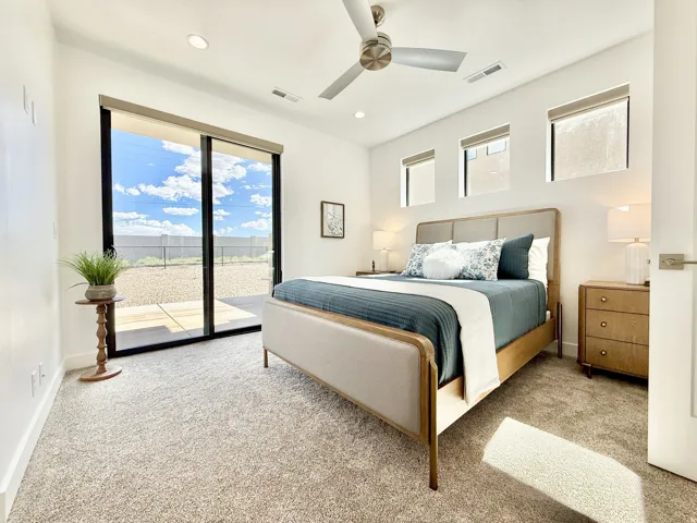 Sliding glass door, recessed lighting, ceiling fan, and carpeted flooring