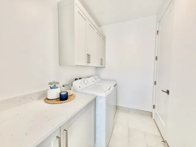 White shaker-style cabinetry, light-toned countertop, and light-toned floor tile