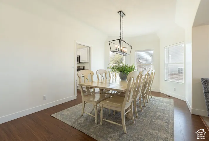 Recessed dining area with a vaulted ceiling, wood-finish flooring, and multiple windows