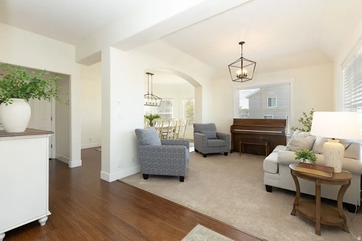 Hardwood flooring, arched doorway, recessed lighting, and a contemporary ceiling fixture