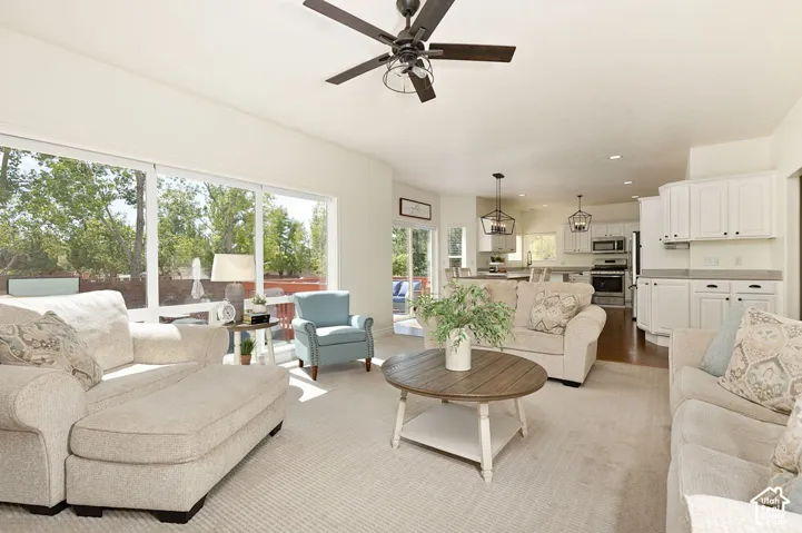 Recessed lighting, ceiling fan, white cabinetry, stainless steel appliances, and large sliding glass doors