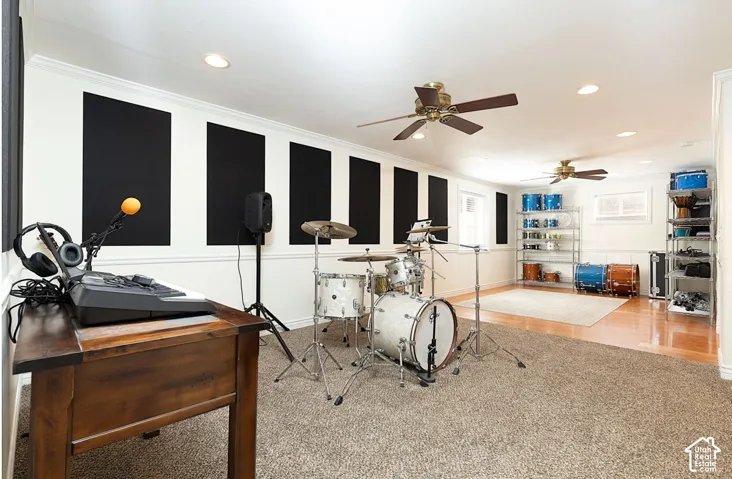Dedicated space featuring wall-mounted acoustic panels, two ceiling fans, recessed lighting, and mixed flooring with carpeting and wood-finish