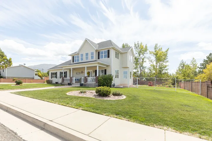 Two-story residence with a covered front porch featuring white columns and a railing