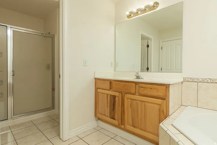Wood-finish vanity with an integrated sink and large wall mirror
