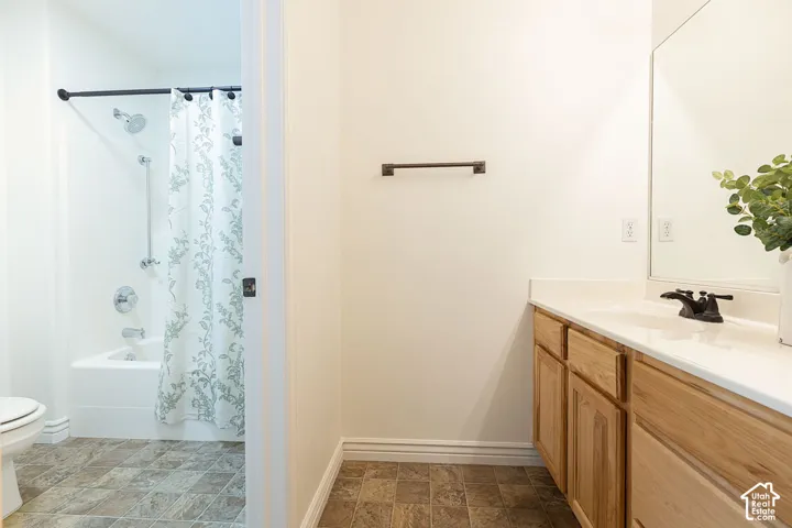 Light wood-finish vanity with white countertop, integrated sink, and dark bronze faucet
