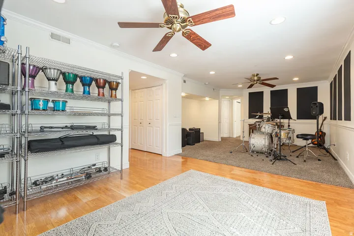 Recessed lighting, wood-finish flooring, two ceiling fans, acoustic paneling, and bi-fold closet doors