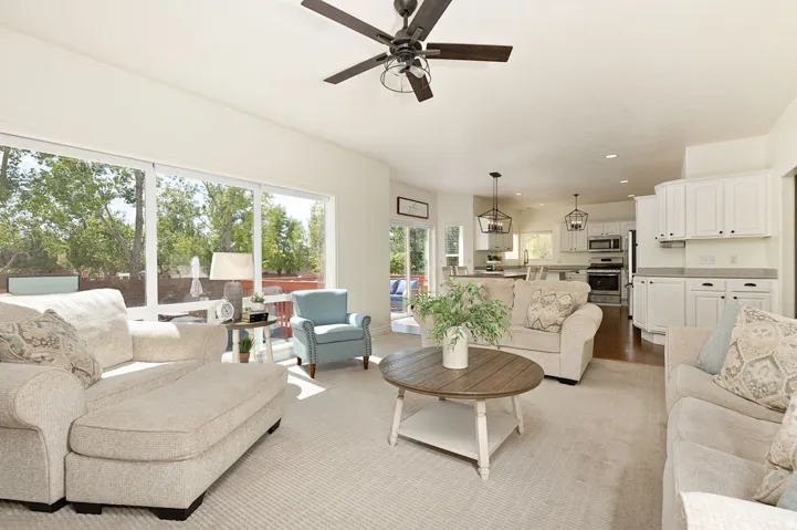 Recessed lighting, ceiling fan, white cabinetry, stainless steel appliances, and large sliding glass doors