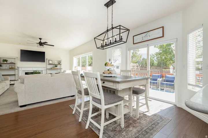 Varnished wood-finish flooring, vaulted ceiling, built-in fireplace, sliding glass door, and a multi-level deck