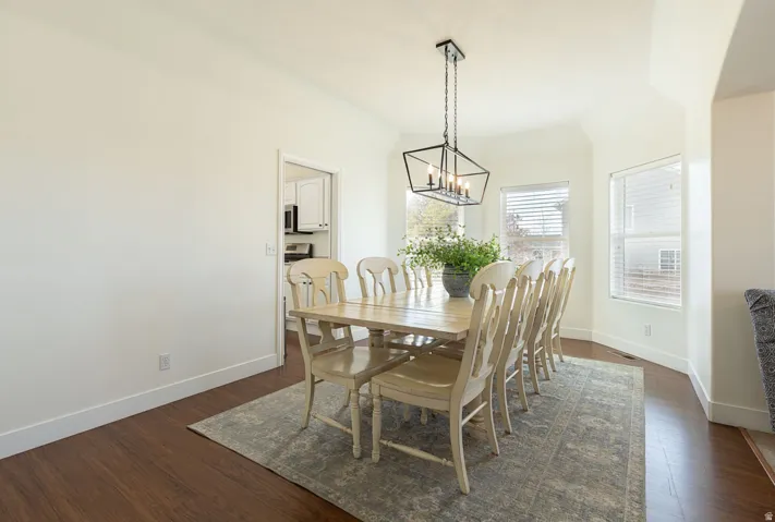 Recessed dining area with a vaulted ceiling, wood-finish flooring, and multiple windows
