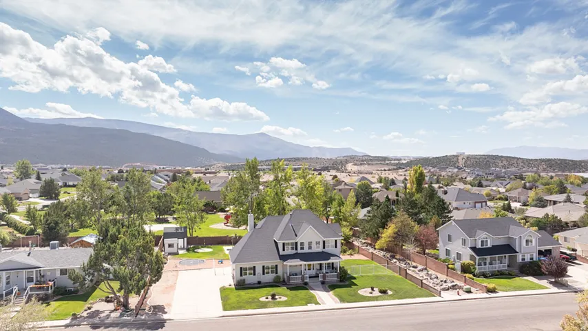 Expansive landscaped grounds with mature trees and a paved driveway