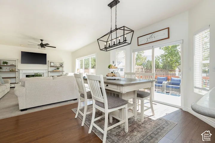 Varnished wood-finish flooring, vaulted ceiling, built-in fireplace, sliding glass door, and a multi-level deck