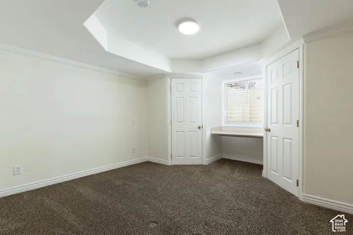 Recessed lighting, built-in desk, paneled doors, and crown molding