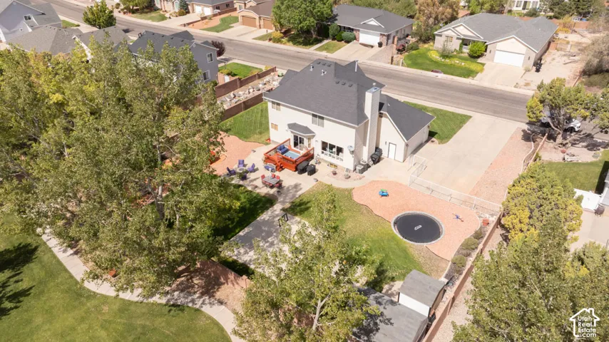 Expansive backyard with a manicured lawn, paved patio, and mature trees