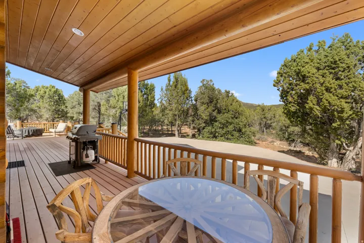 Expansive covered deck featuring wood plank flooring and wood-paneled ceiling