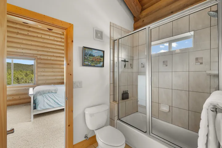 Jack and Jill bathroom with tub/shower combination, tile surround and glass enclosure