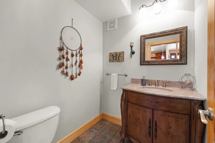 Half bathroom with corner vanity with an integrated sink and light-toned countertop